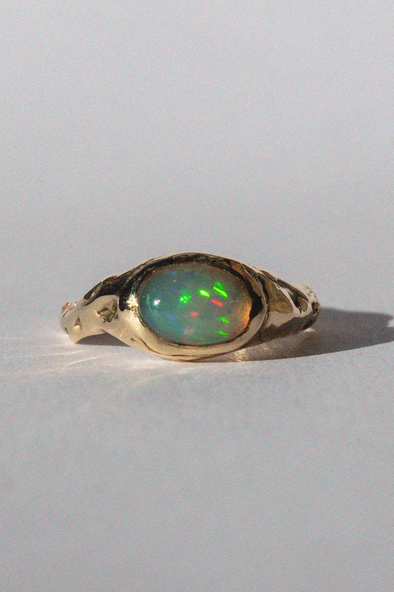 gold and opal ring on a white background