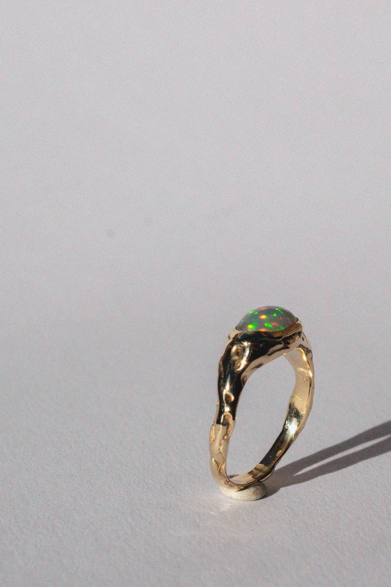 gold and opal ring on a white background