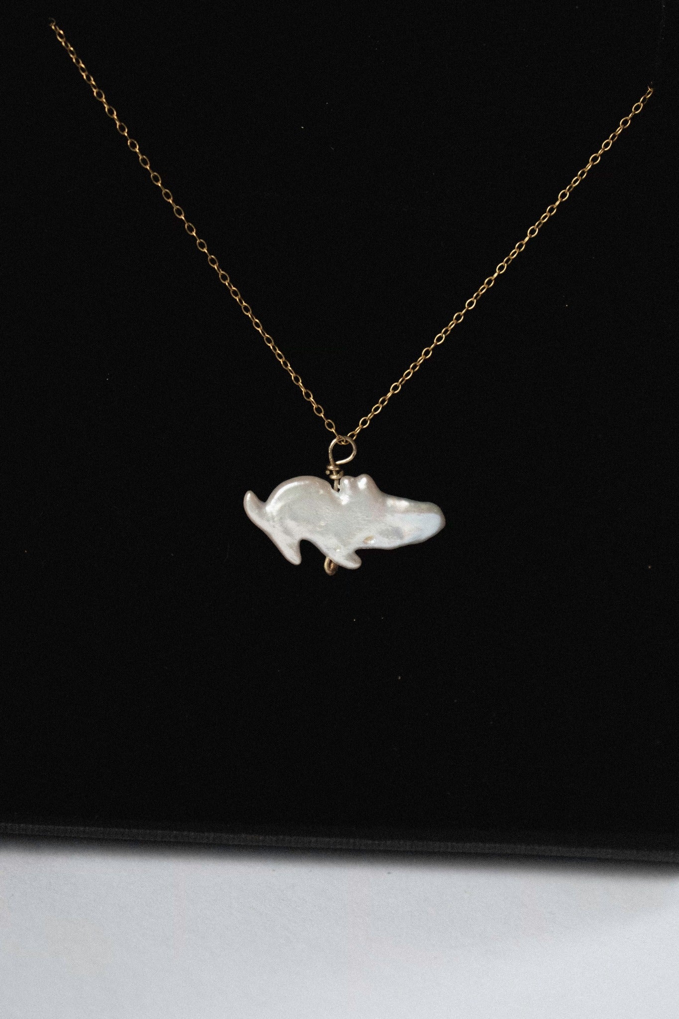 a pendant with a freshwater pearl that looks like a moomin in a black jewellery box