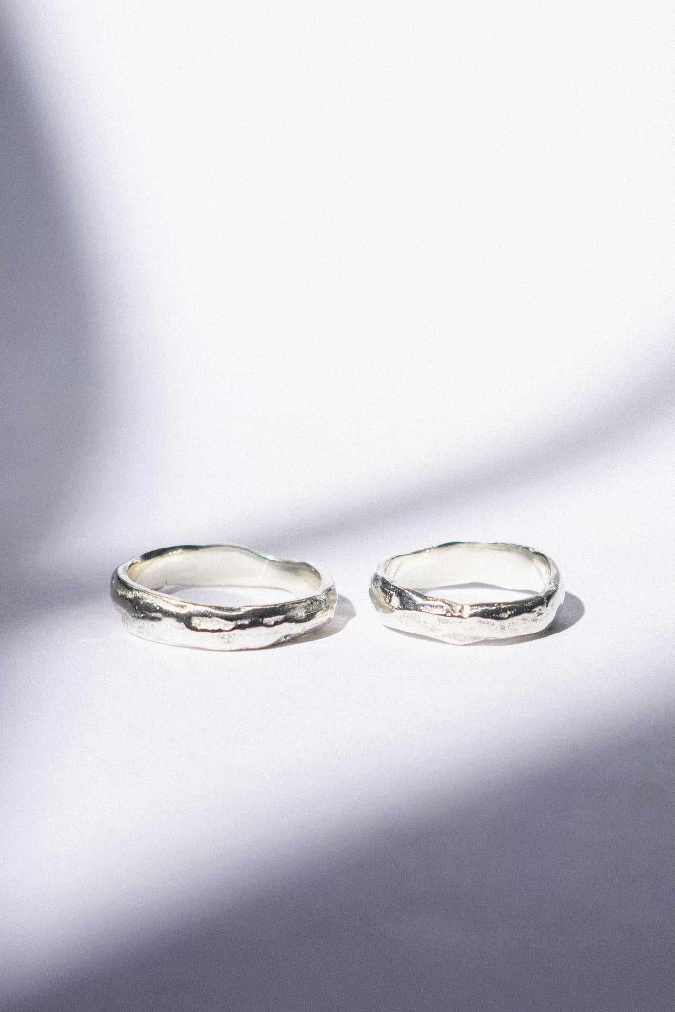 two white gold wedding bands on a white background