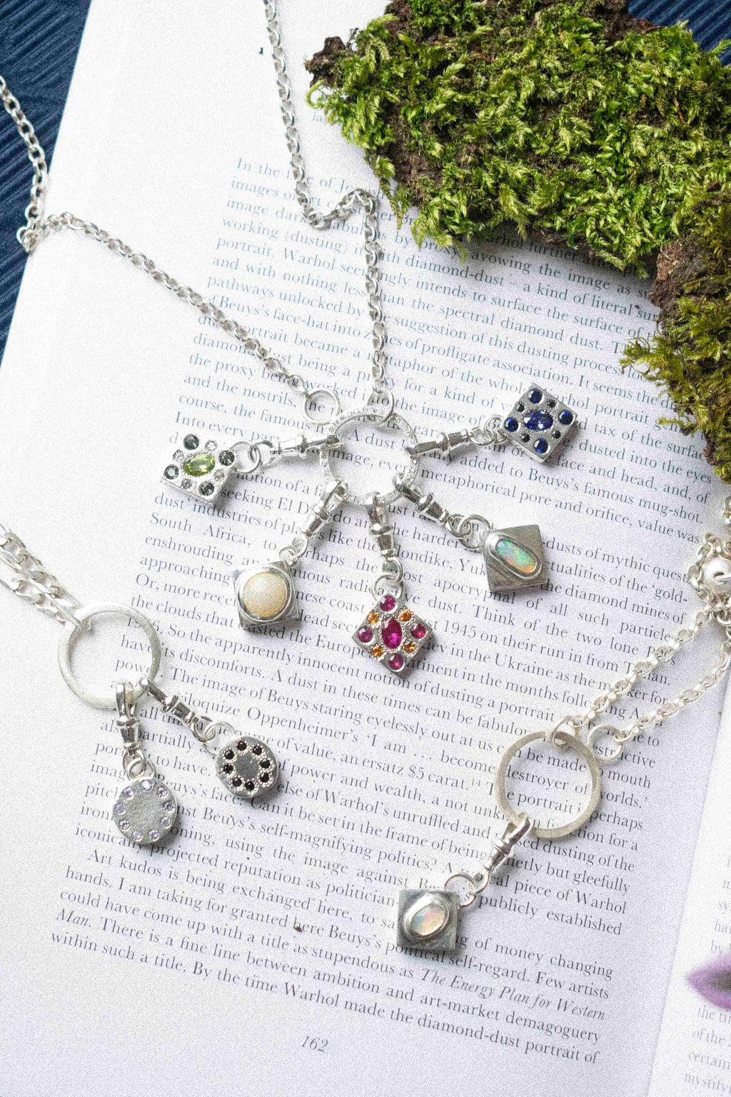 many charm necklace / bracelet displayed on book text background