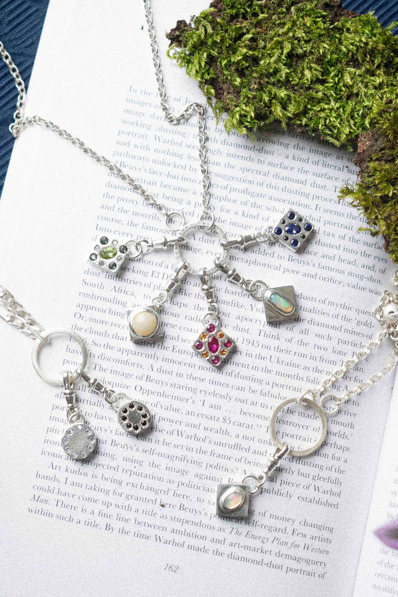 many charm necklace / bracelet displayed on book text background