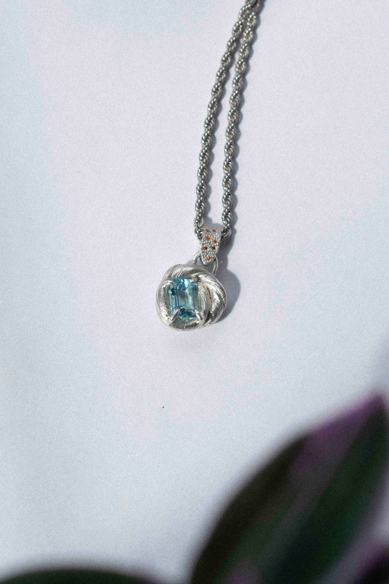 mitsuro wax pendant with a bright blue topaz in the centre