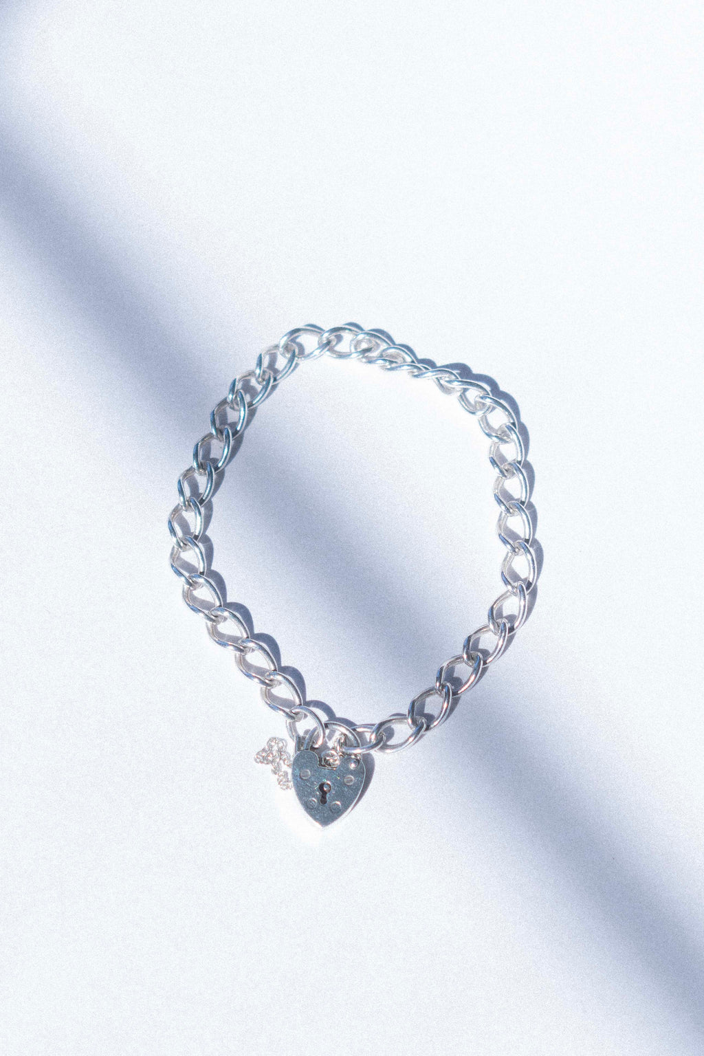 a charm bracelet with a love hear clasp on a white background