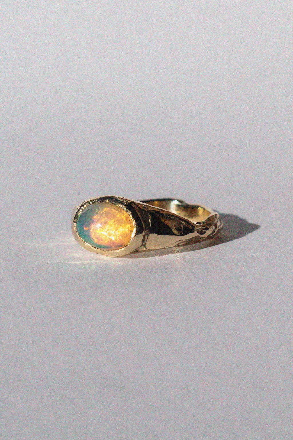 gold and opal ring on a white background