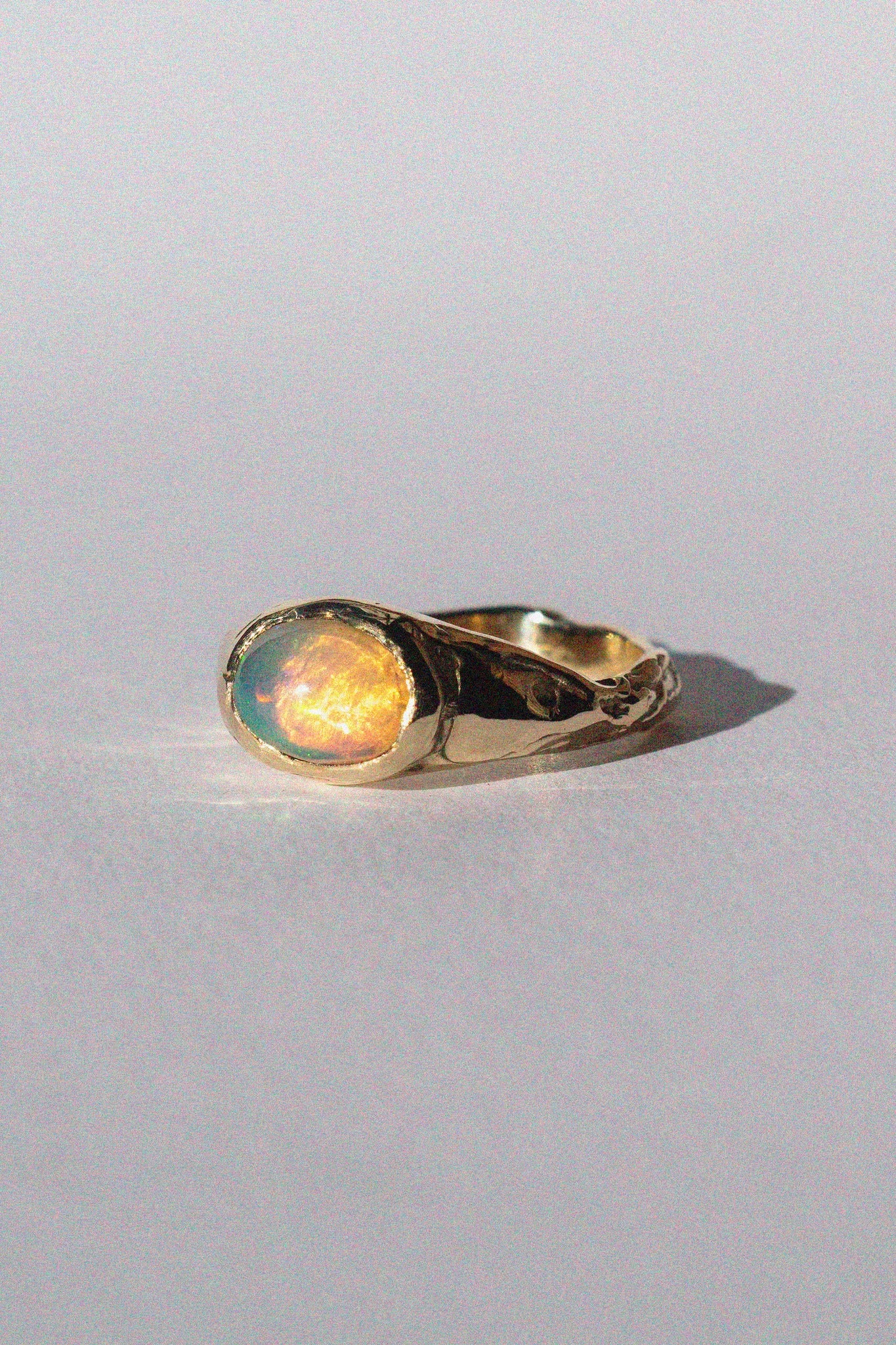 gold and opal ring on a white background