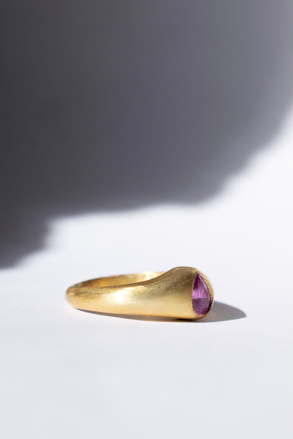 gold and pink sapphire ring on a white background 