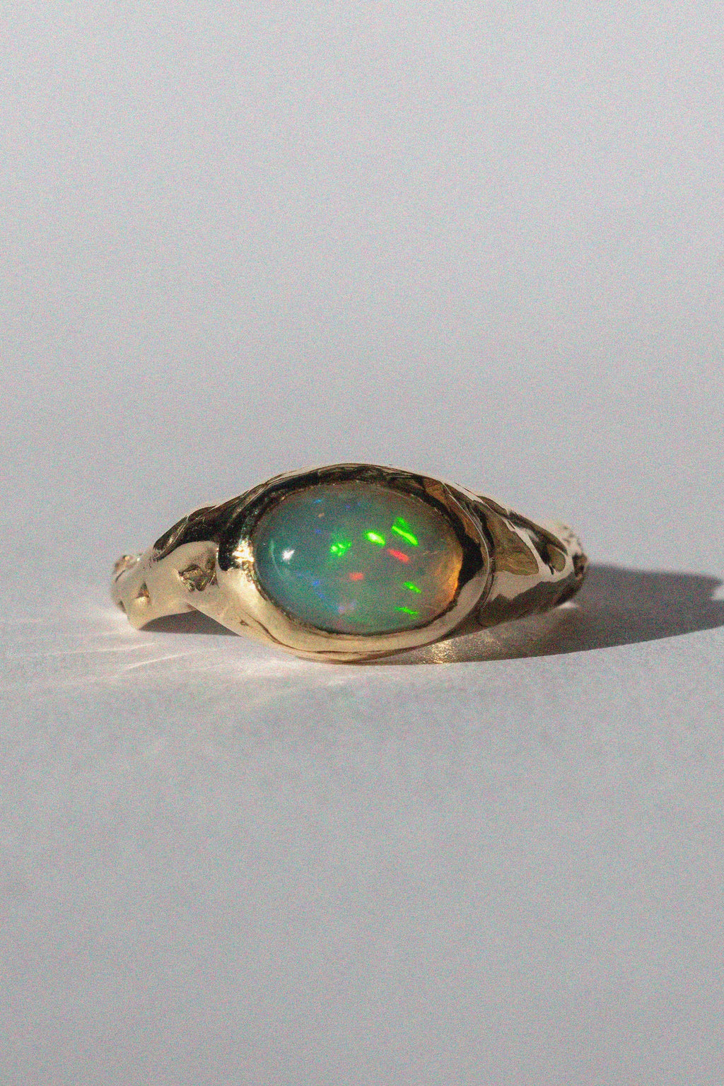 gold and opal ring on a white background