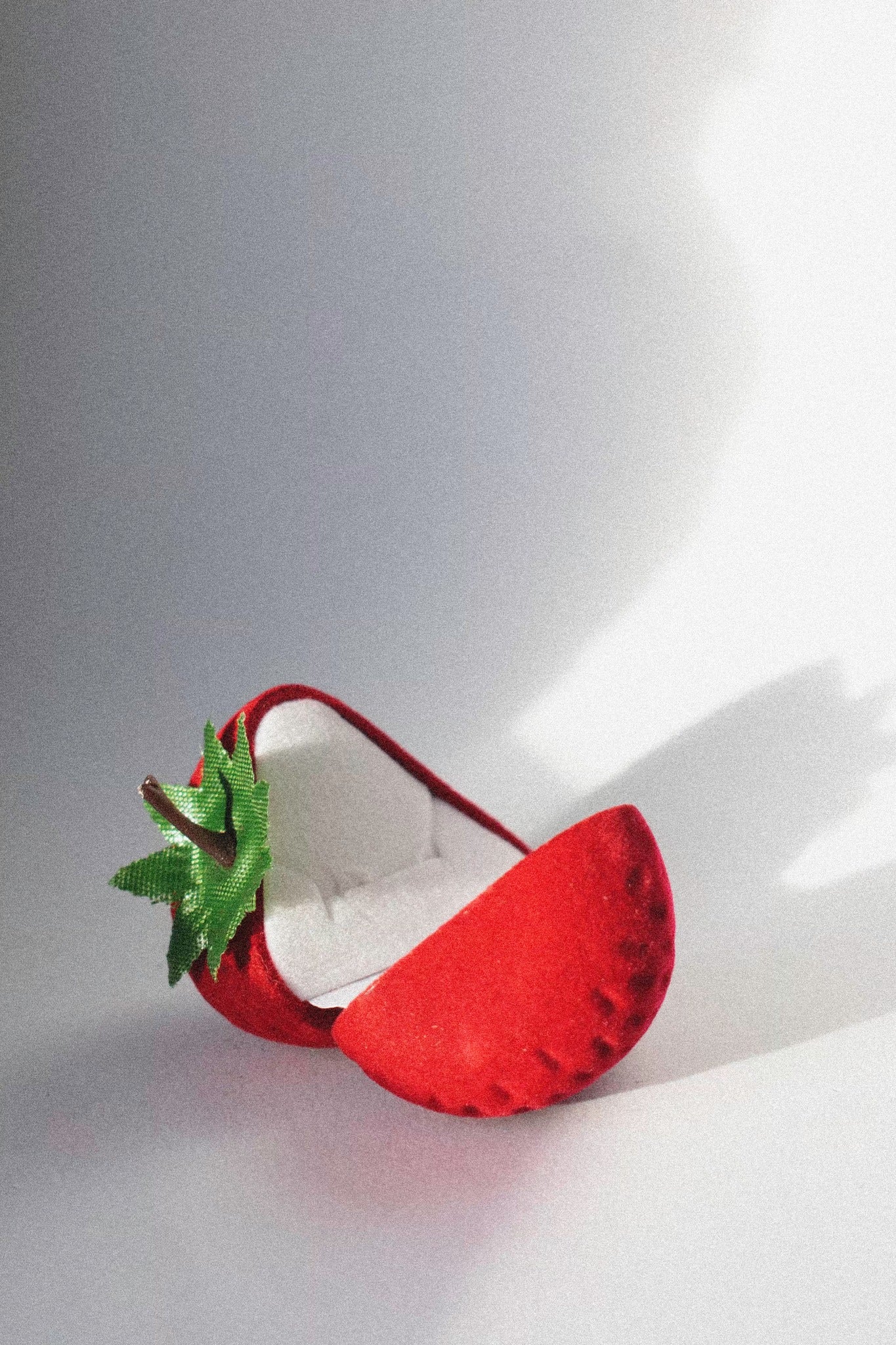 a strawberry ring box on a white background