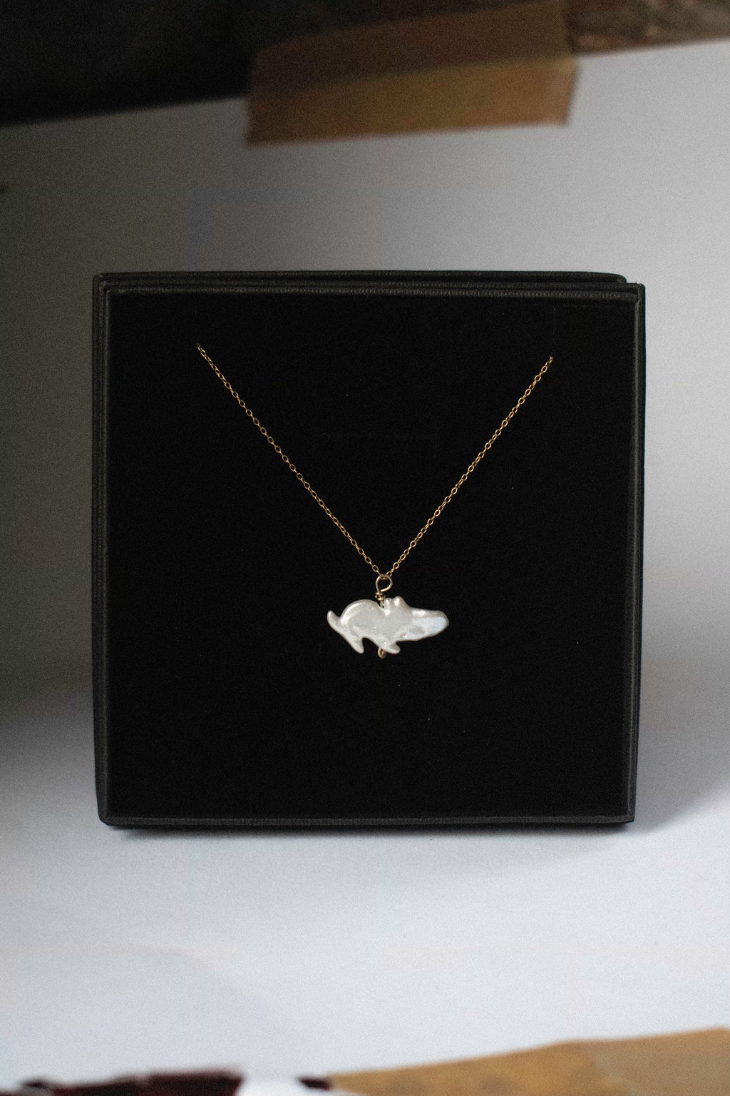 a pendant with a freshwater pearl that looks like a moomin in a black jewellery box
