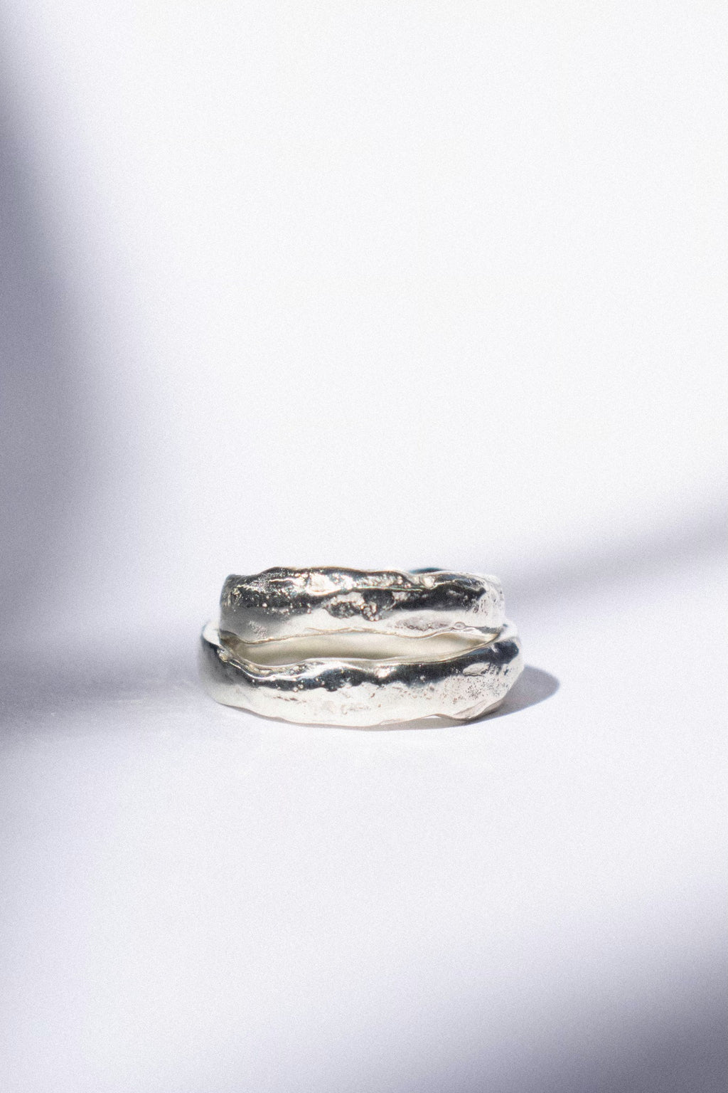 two white gold wedding bands on a white background 