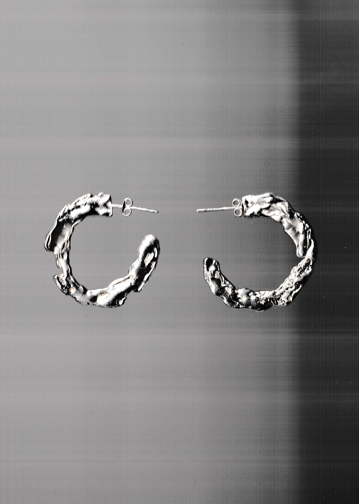 silver earrings on a grey background