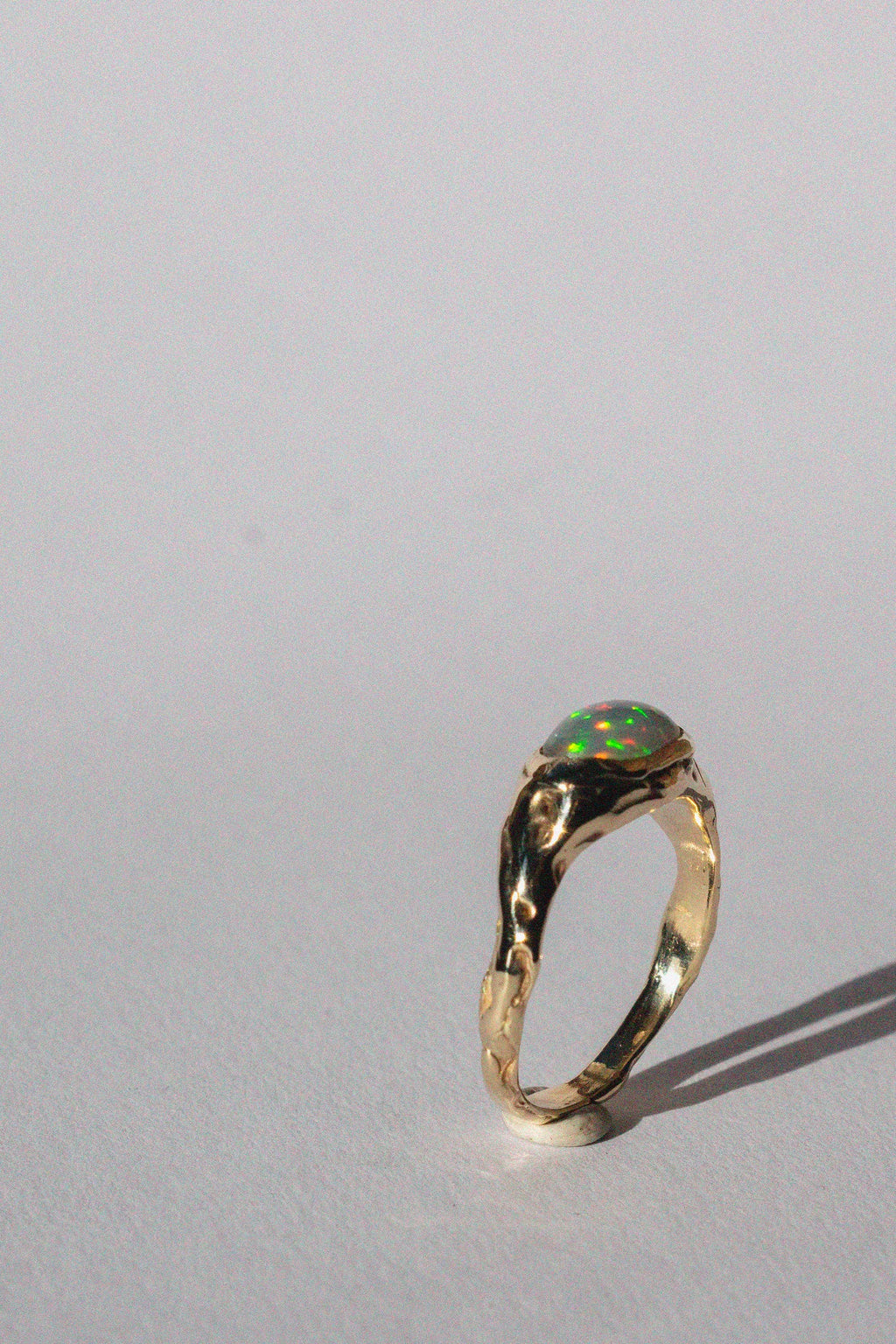 gold and opal ring on a white background