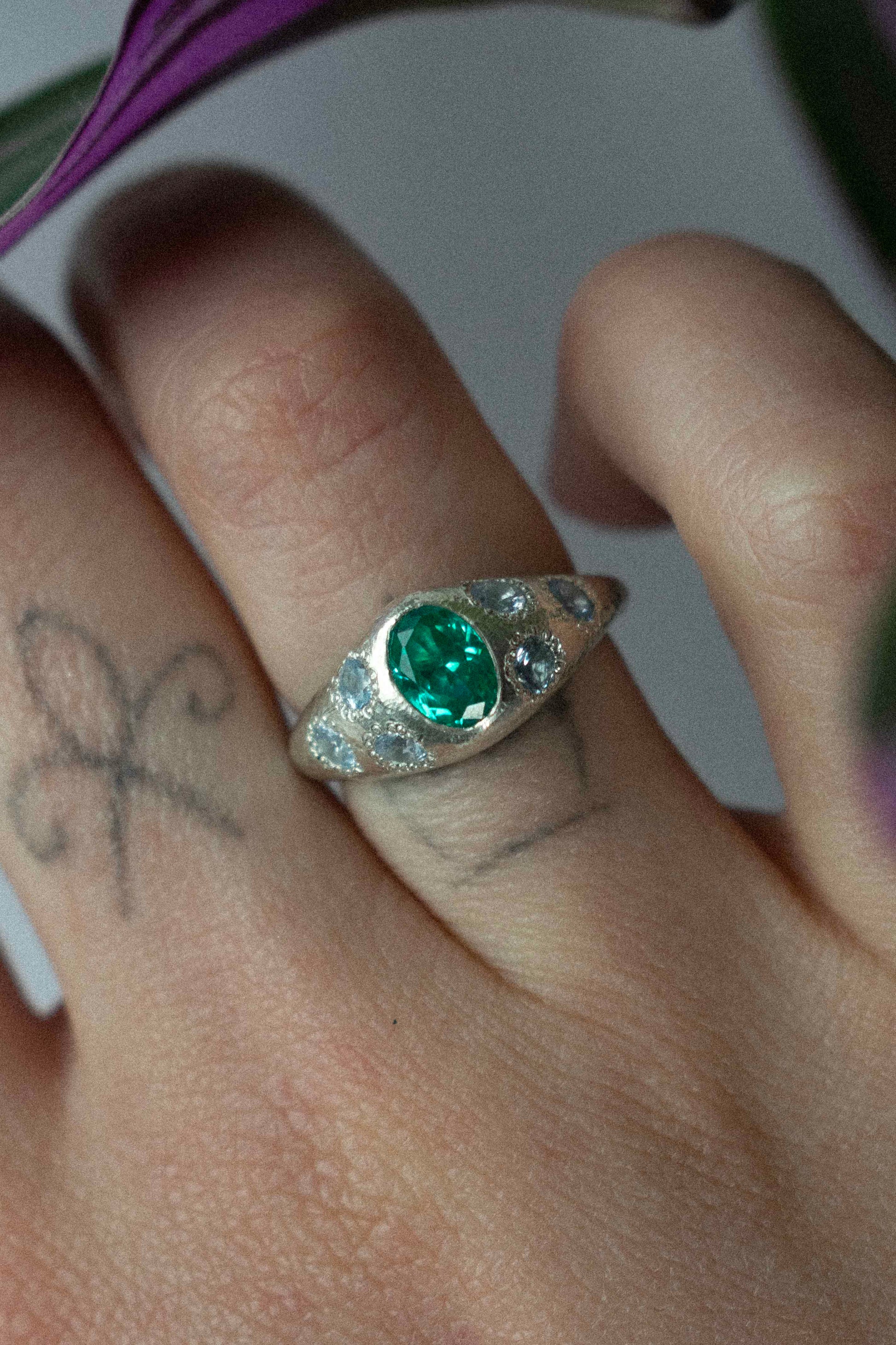 a silver ring with blue gemstones on a hand