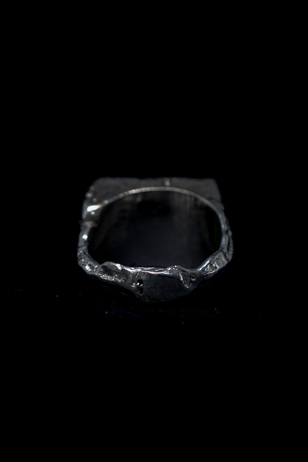 silver raw signet ring on a black background