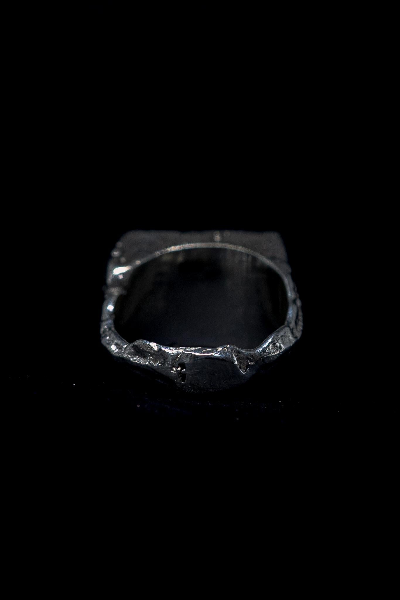 silver raw signet ring on a black background