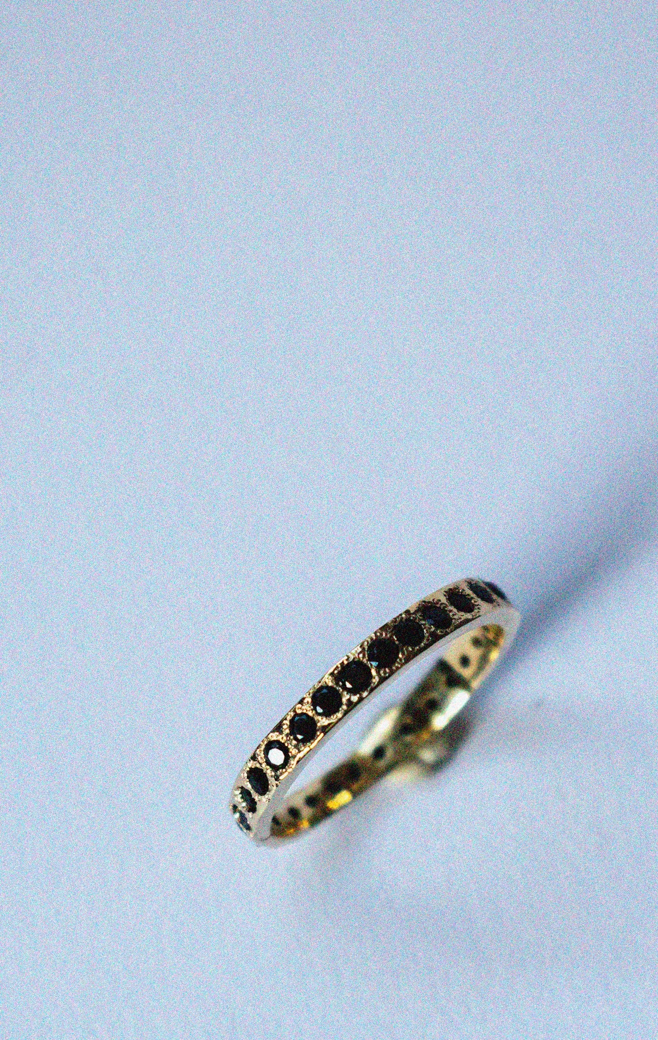 gold and spinel eternity band on a white background 