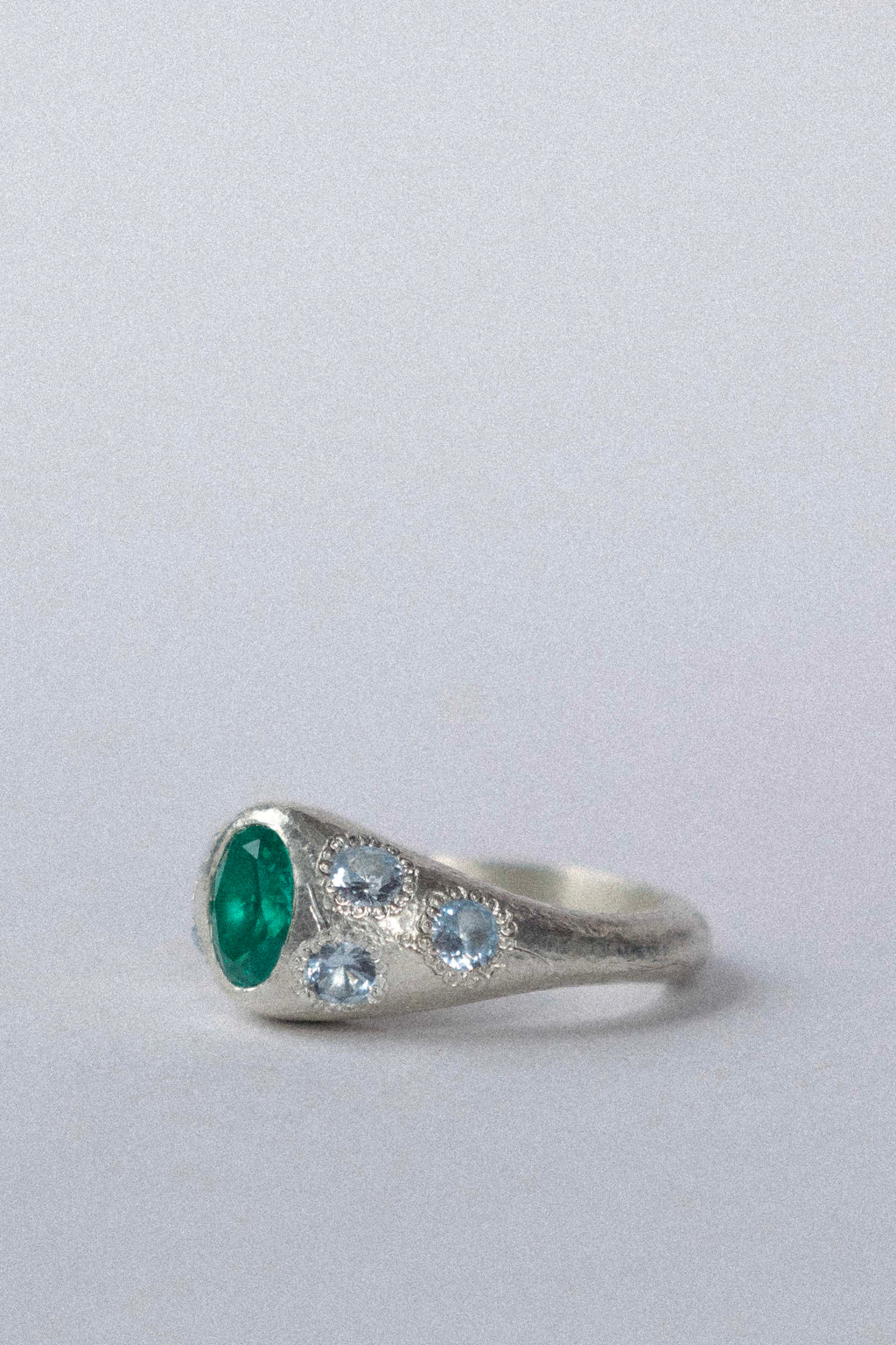 a silver ring with blue gemstones on a white background 