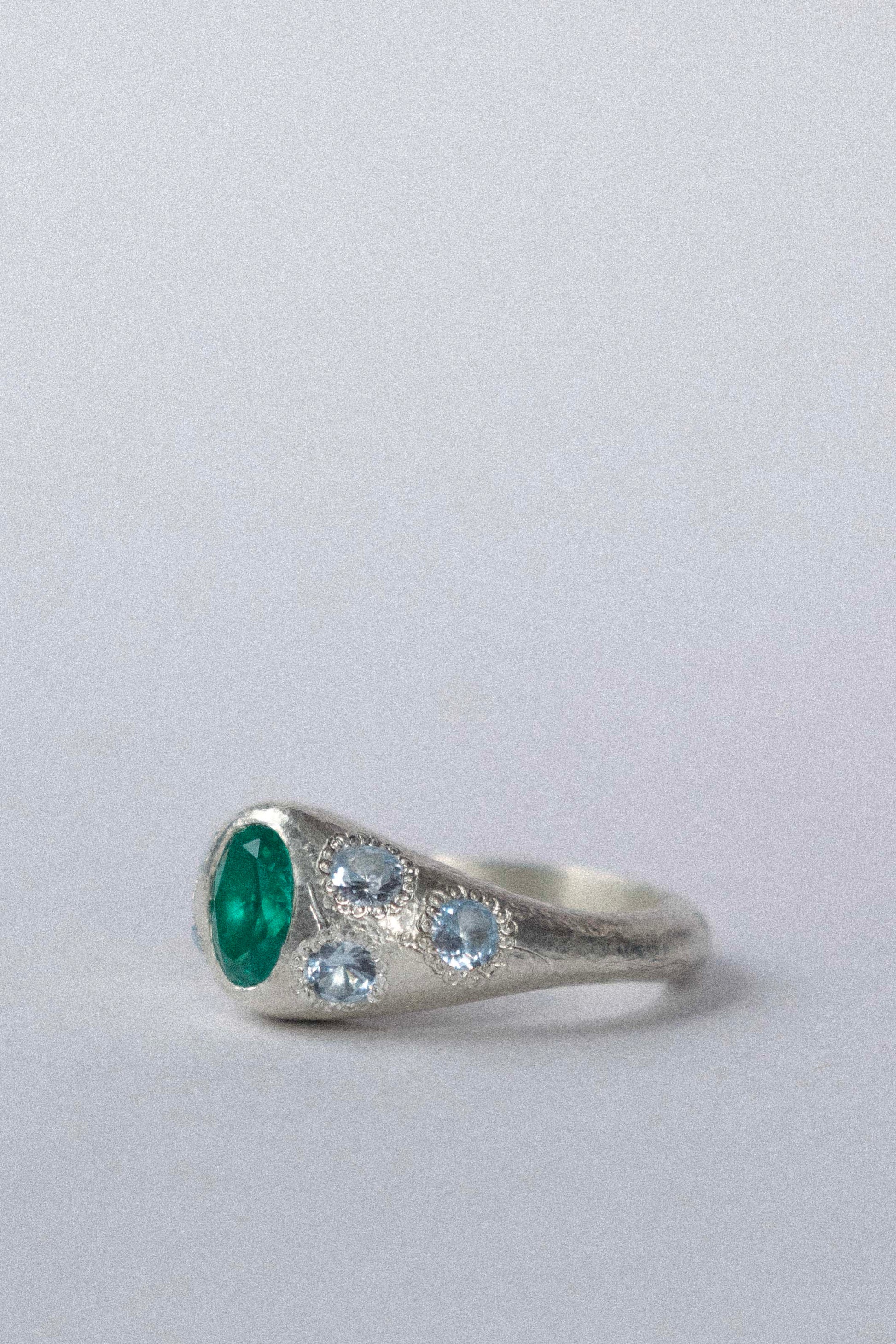 a silver ring with blue gemstones on a white background 
