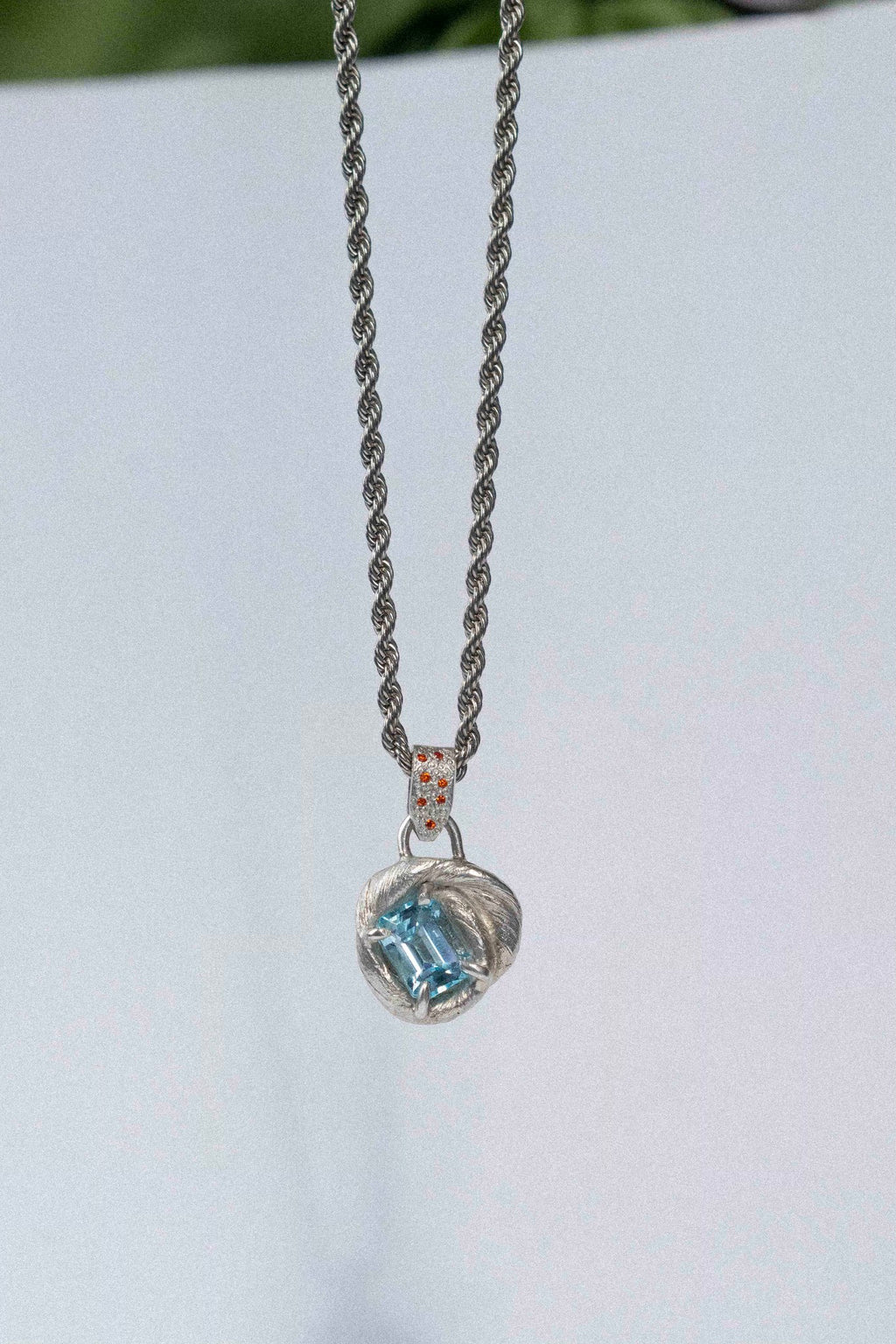 mitsuro wax pendant with a bright blue topaz in the centre