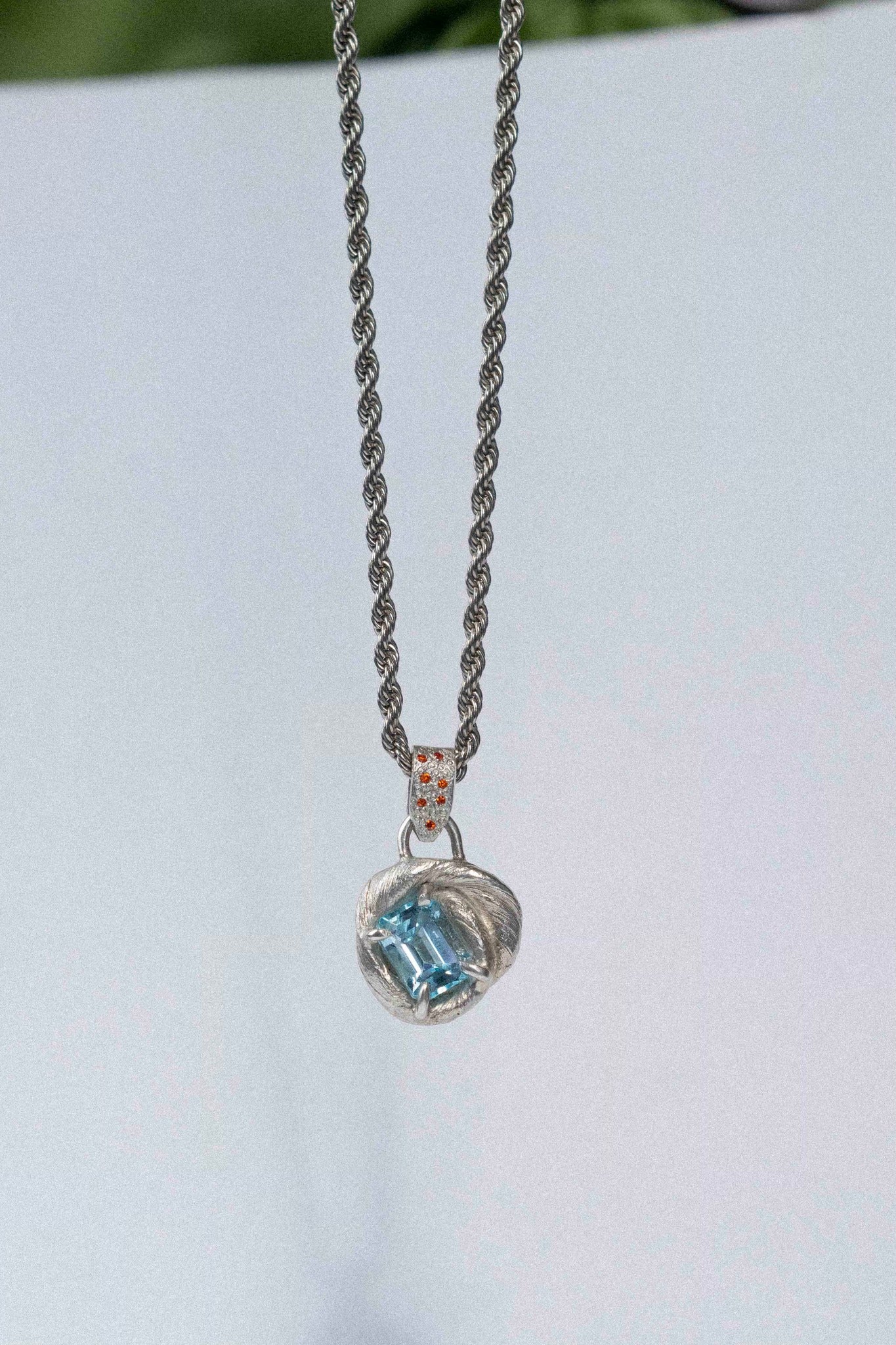 mitsuro wax pendant with a bright blue topaz in the centre