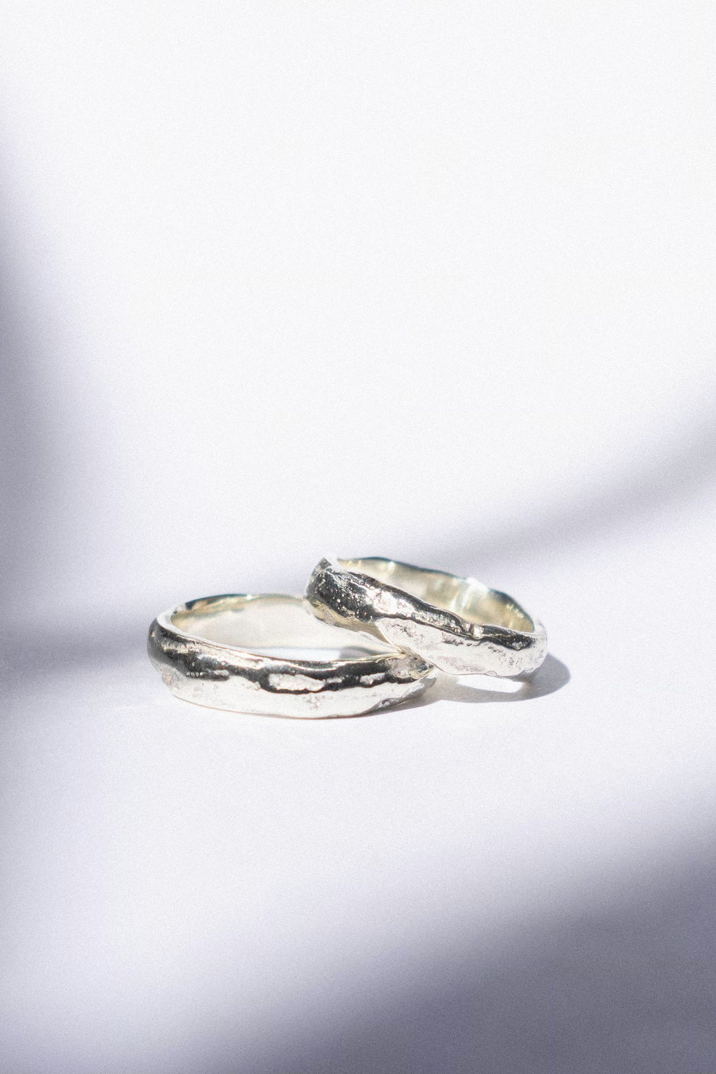 two white gold wedding bands on a white background 