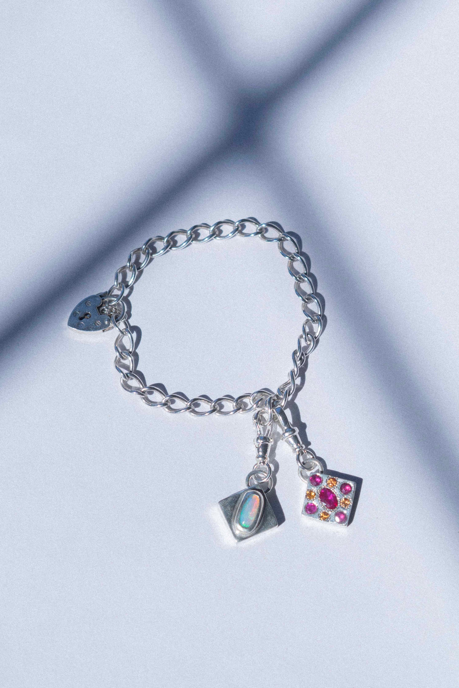 a charm bracelet with a love hear clasp on a white background