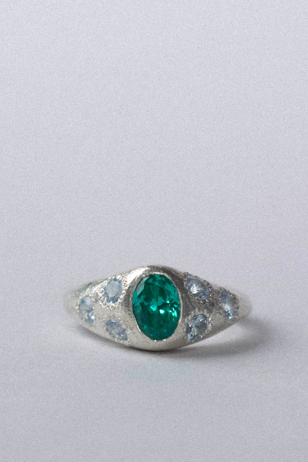 a silver ring with blue gemstones on a white background 