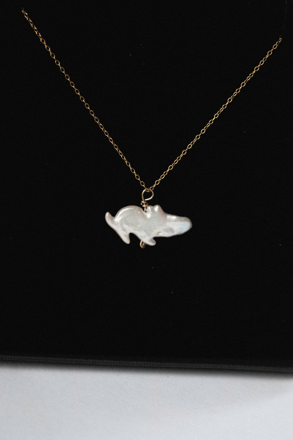 a pendant with a freshwater pearl that looks like a moomin in a black jewellery box