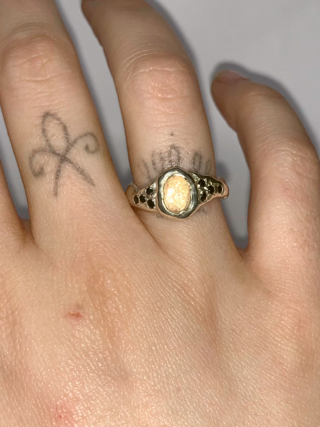 silver and opal ring on a hand