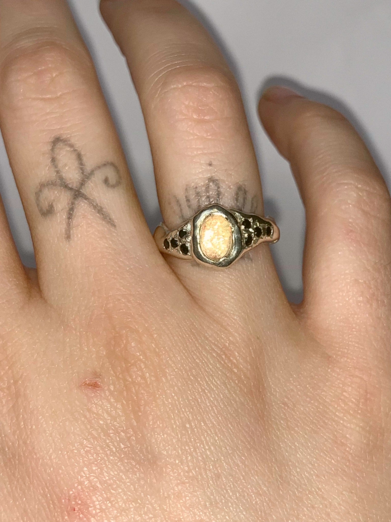 silver and opal ring on a hand
