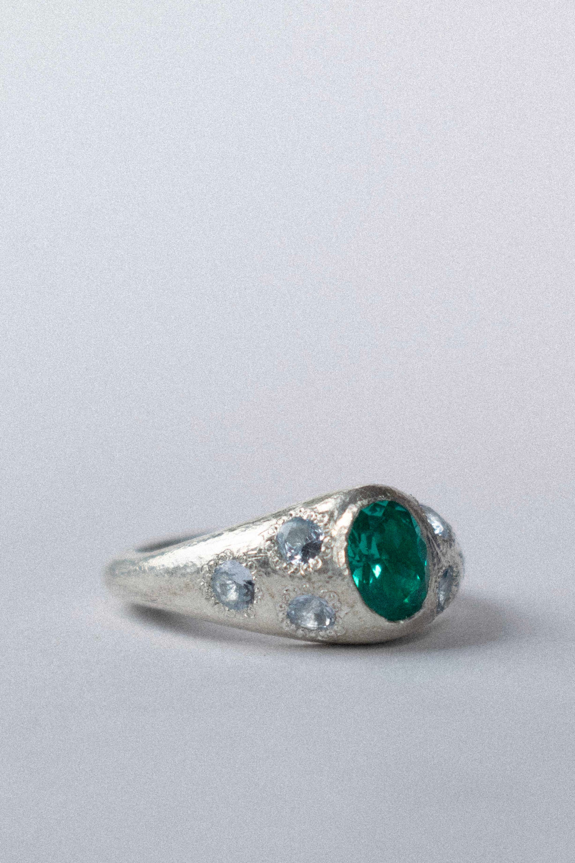 a silver ring with blue gemstones on a white background 