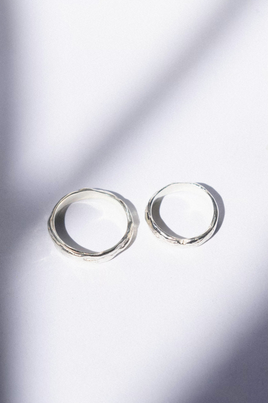 two white gold wedding bands on a white background 