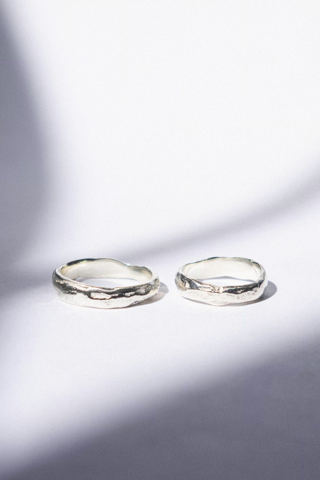 two white gold wedding bands on a white background 