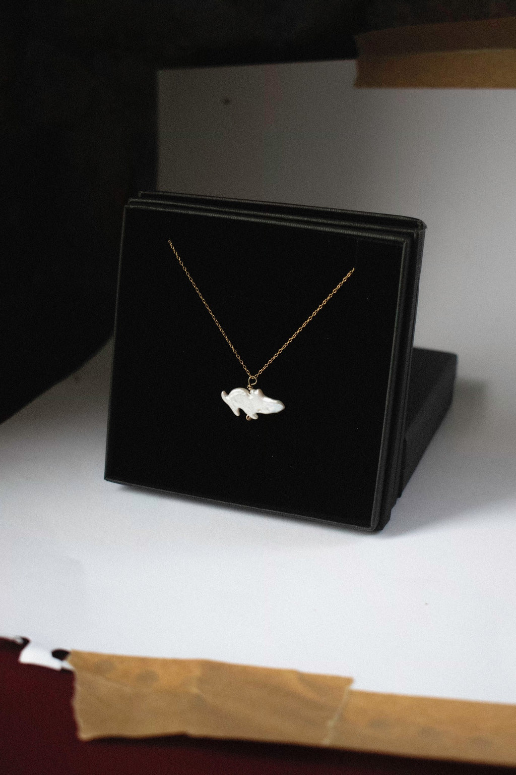 a pendant with a freshwater pearl that looks like a moomin in a black jewellery box