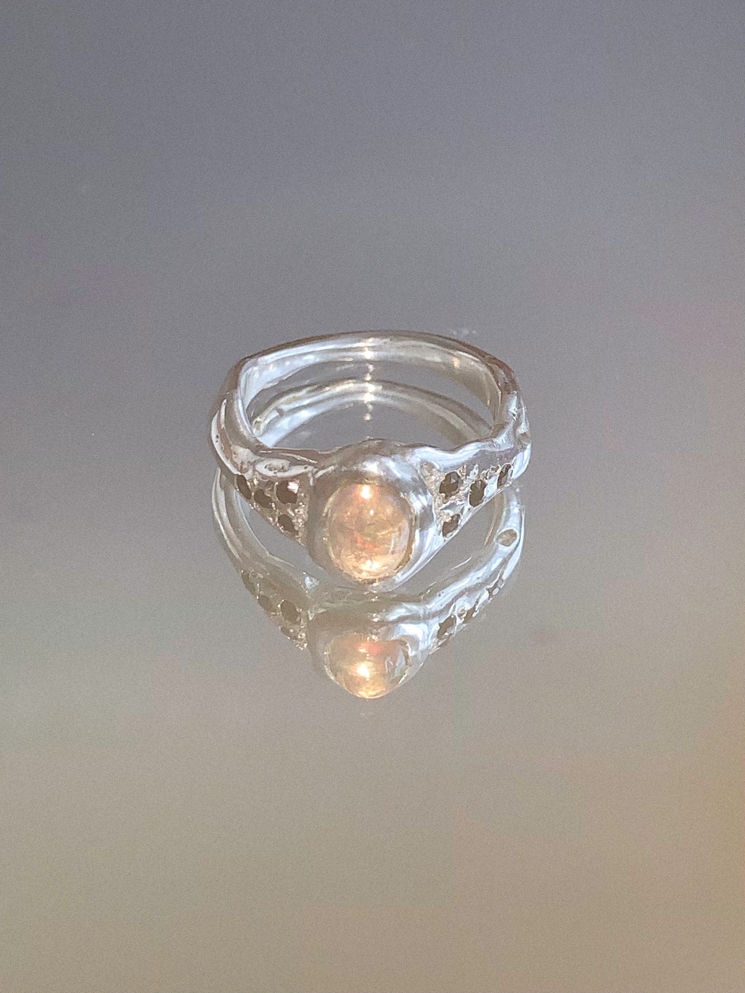 silver and opal ring on a mirror